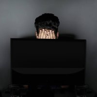 man covering face and computer