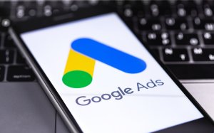 a smart phone showing the google ads logo on top of a computer keyboard
