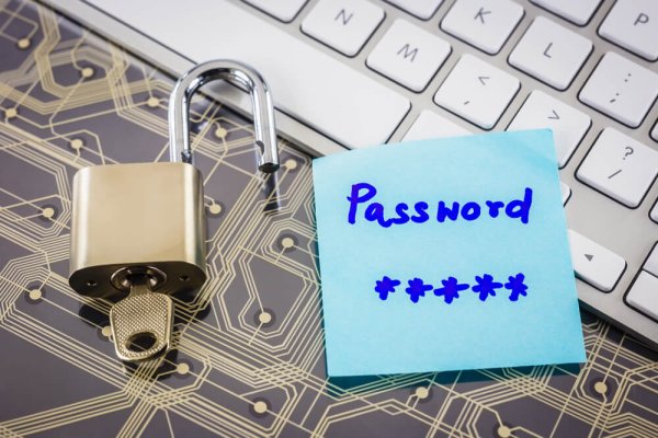 keyboard, padlock, and the word "password" written on a blue sticky note