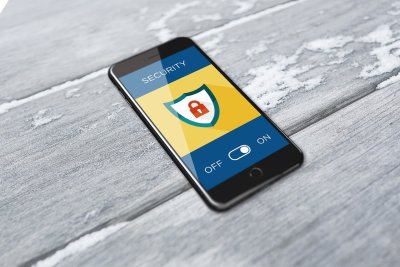 a black iphone on a grey background with the word security and a shield with a padlock inside of it