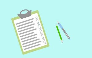 white clipboard with a green pencil and blue pen next to it